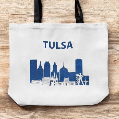 Large Tulsa skyline tote bag shown flat on wood surface featuring navy Tulsa city skyline design