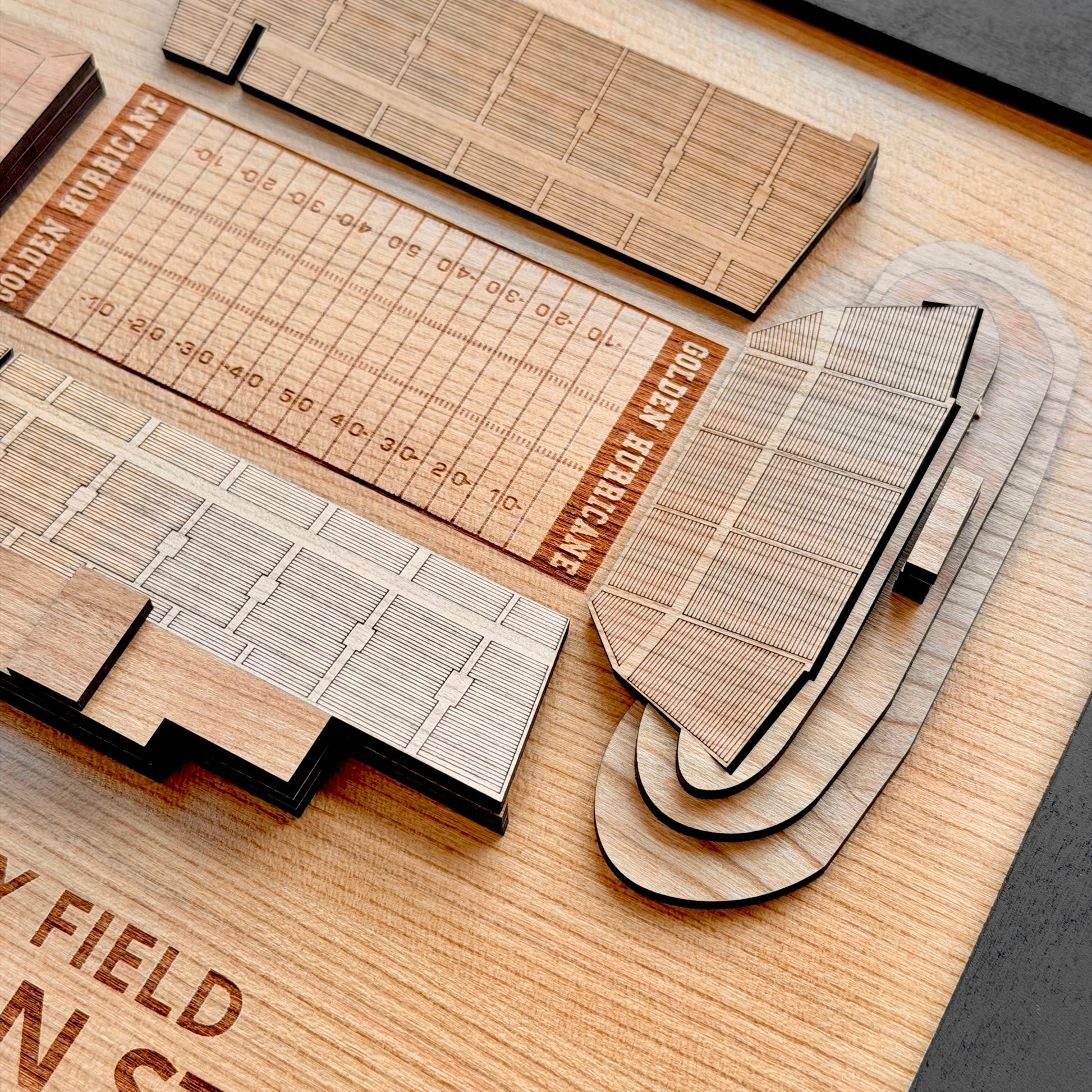 Close up detail of layered wood H.A. Chapman Stadium wall art showing engraved football field lines seating sections and dimensional wood layers for Tulsa sports collectors