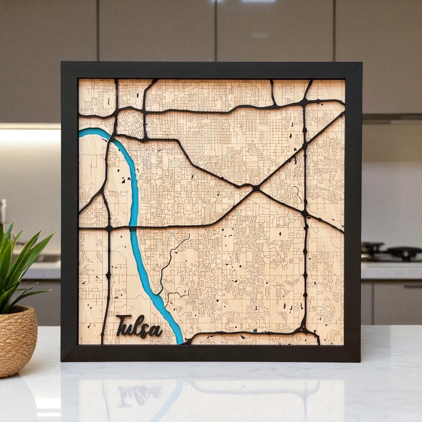 Large framed Tulsa wooden city map displayed on a countertop, layered wood wall art with engraved streets and river detail