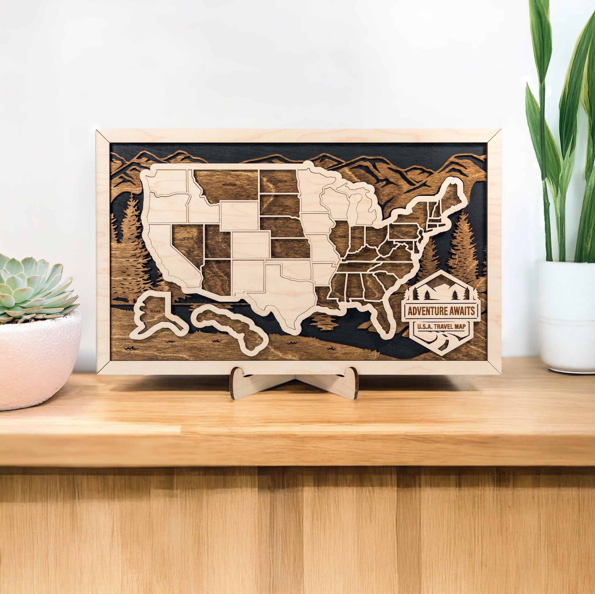 Front view of framed wooden USA travel map with layered mountains and engraved states