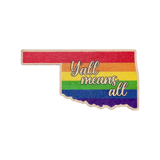 Oklahoma shaped wooden veneer sticker with rainbow stripes and the phrase y’all means all, real wood sticker showing inclusive Pride message