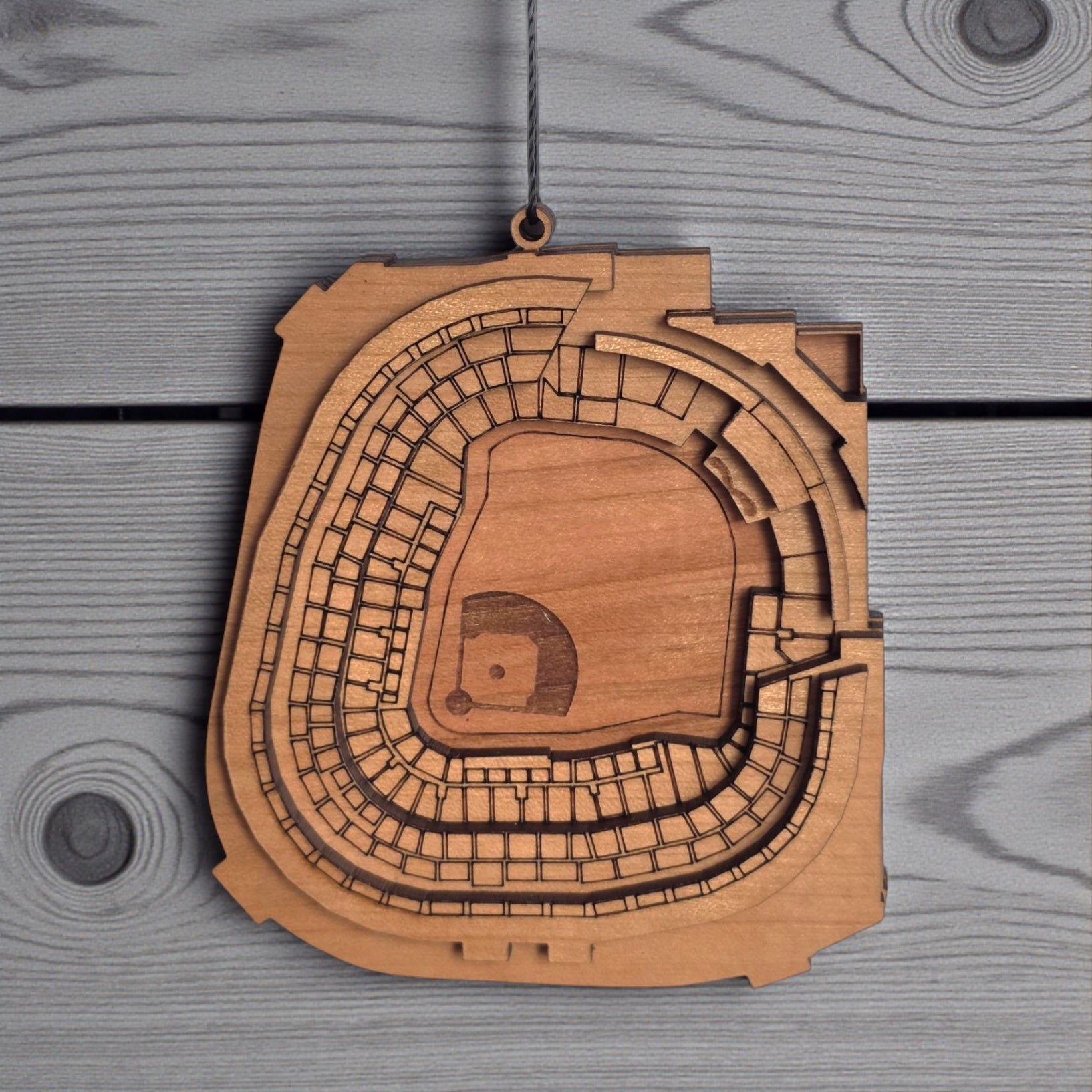 Close up of Yankee Stadium wooden ornament showing engraved seating sections and layered wood construction, detailed MLB stadium ornament